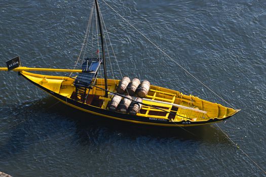 Top 5 Avantaje ale Carierei de Radiotelefonist pe Mare în 2026 4 A vibrant yellow Rabelo boat carrying barrels on the Douro River in Porto, Portugal.