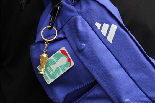Close-up of a FIFA World Cup keychain on a purple bag, symbolizing soccer culture.